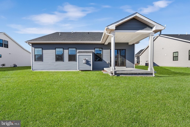 rear view of house featuring a lawn