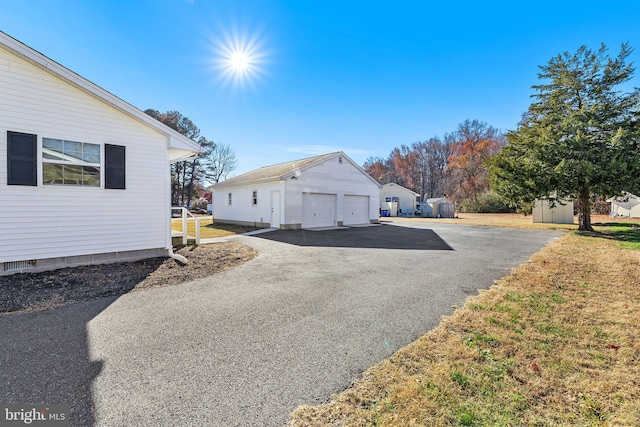 view of side of home with a garage and a storage shed