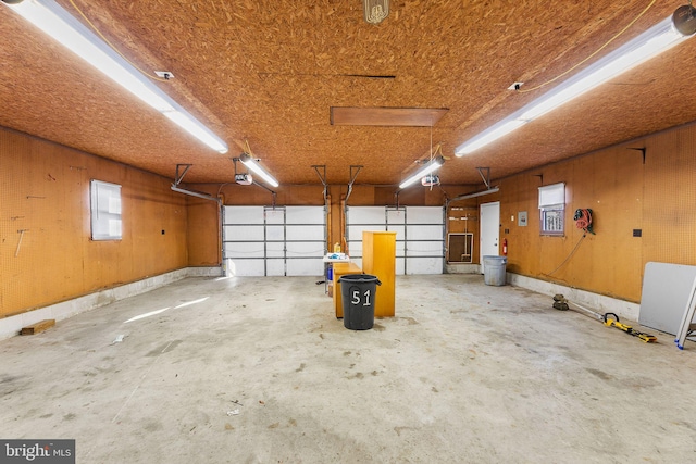 garage featuring wood walls and a garage door opener