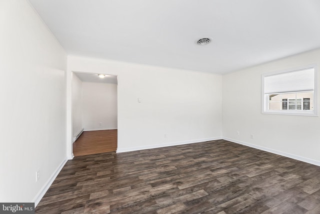 unfurnished room featuring dark hardwood / wood-style flooring, baseboard heating, and crown molding