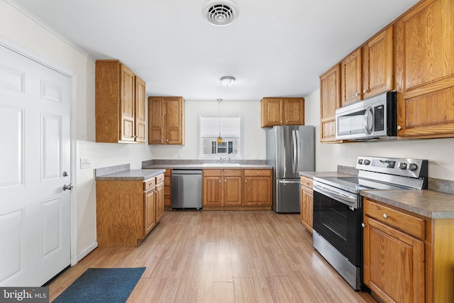 kitchen featuring appliances with stainless steel finishes, light wood-type flooring, and sink