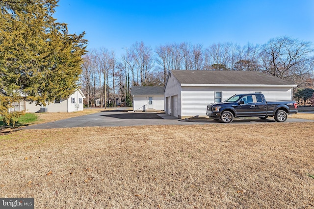 view of property exterior featuring an outbuilding, a yard, and a garage