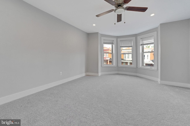 carpeted spare room featuring ceiling fan