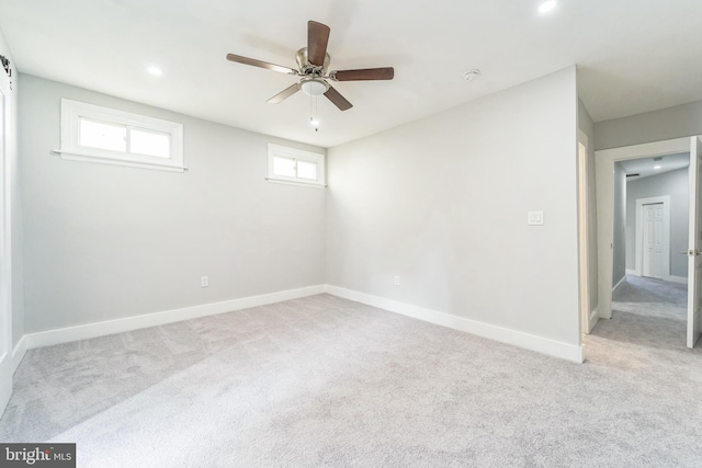 empty room featuring ceiling fan and light carpet