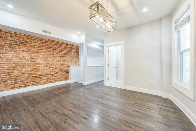 829 Chauncey Ave, Baltimore, MD 21217 - unfurnished room with brick wall, wood finished floors, plenty of natural light, baseboards, and a chandelier