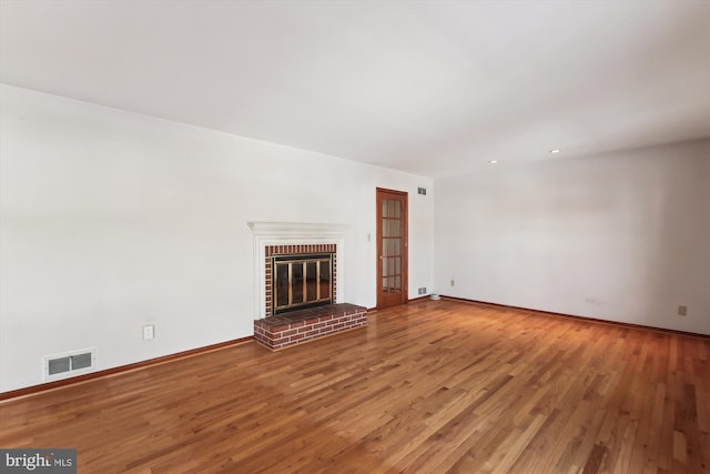 unfurnished living room featuring a fireplace and wood-type flooring