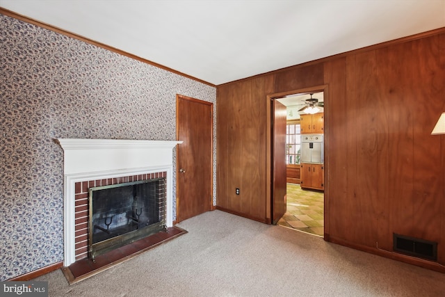 unfurnished living room featuring light carpet, a brick fireplace, and ornamental molding