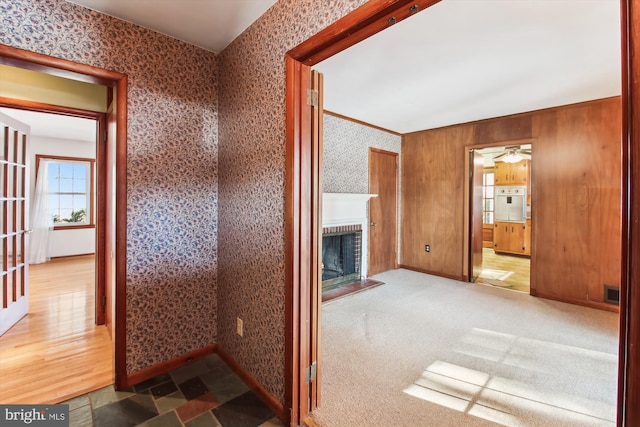 hall featuring carpet floors and wood walls