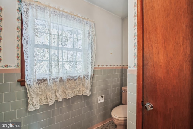 bathroom featuring toilet, tile walls, and tile patterned floors