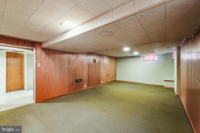 basement with dark colored carpet and wooden walls