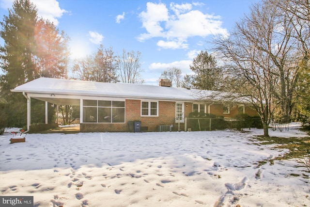 snow covered back of property with cooling unit