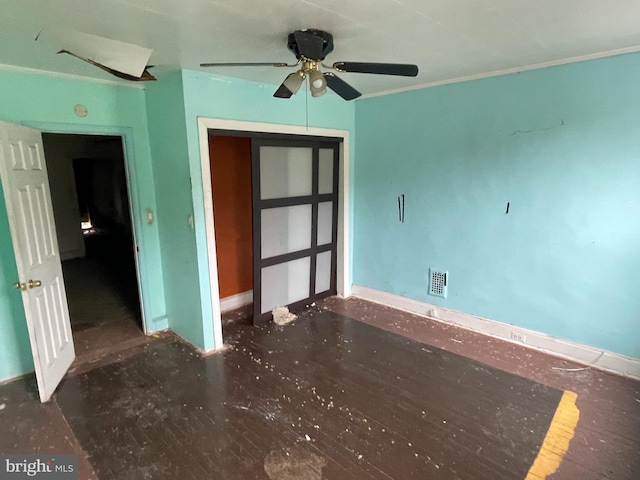 empty room with dark hardwood / wood-style flooring, ceiling fan, and ornamental molding