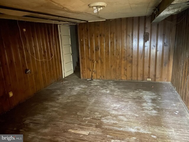 basement with wooden walls and dark hardwood / wood-style floors