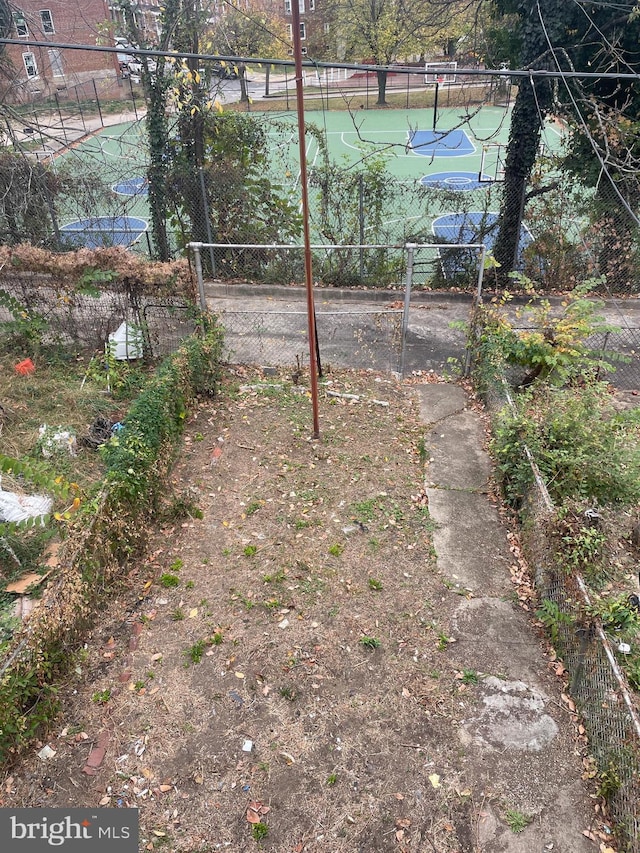 view of yard featuring basketball hoop