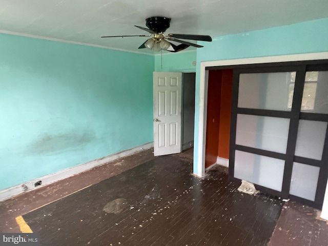 unfurnished bedroom featuring ceiling fan, dark hardwood / wood-style flooring, and a closet