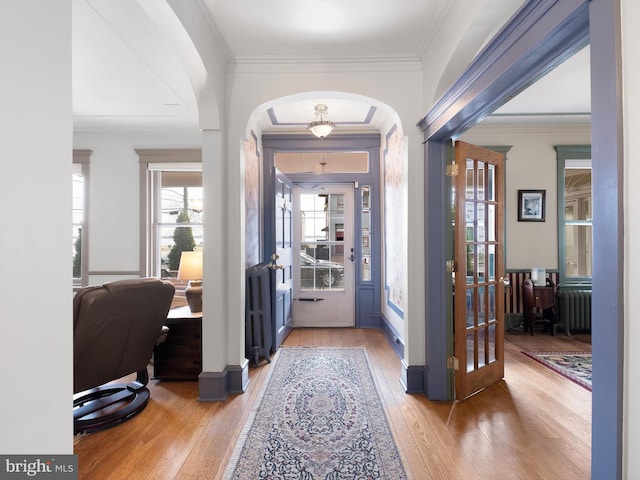 foyer with french doors, hardwood / wood-style flooring, radiator, and crown molding