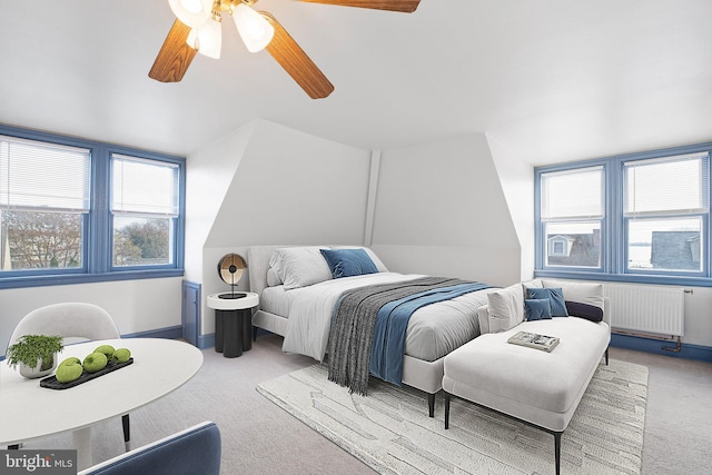 carpeted bedroom with radiator and ceiling fan