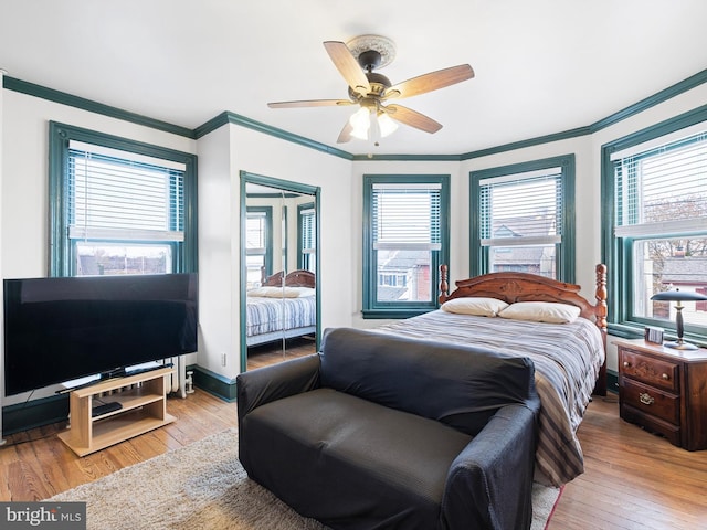 bedroom featuring multiple windows, ceiling fan, and light hardwood / wood-style flooring