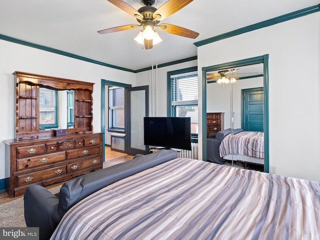 bedroom with ceiling fan, crown molding, and light hardwood / wood-style flooring