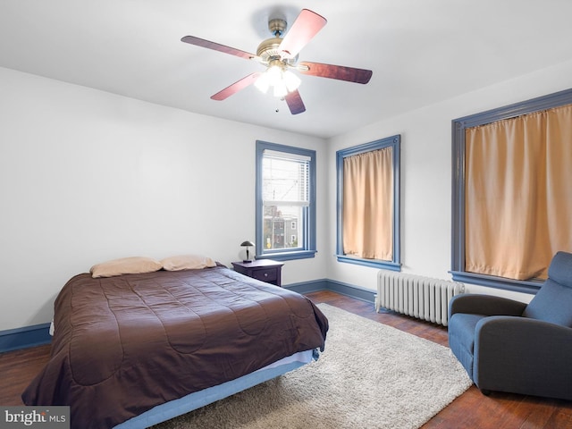 bedroom featuring radiator heating unit, ceiling fan, and dark wood-type flooring