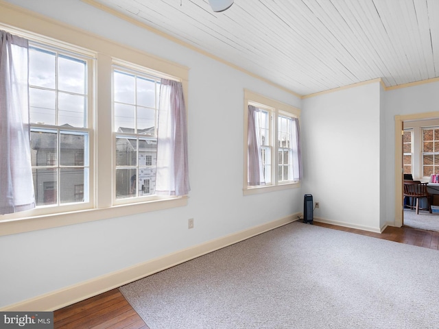 empty room with wood-type flooring, wood ceiling, and ornamental molding