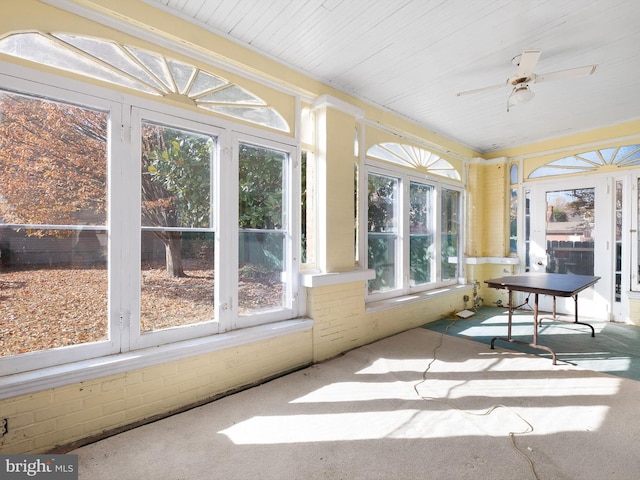 unfurnished sunroom featuring ceiling fan and a healthy amount of sunlight