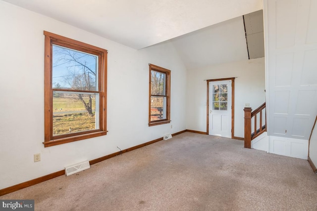 carpeted foyer entrance with lofted ceiling