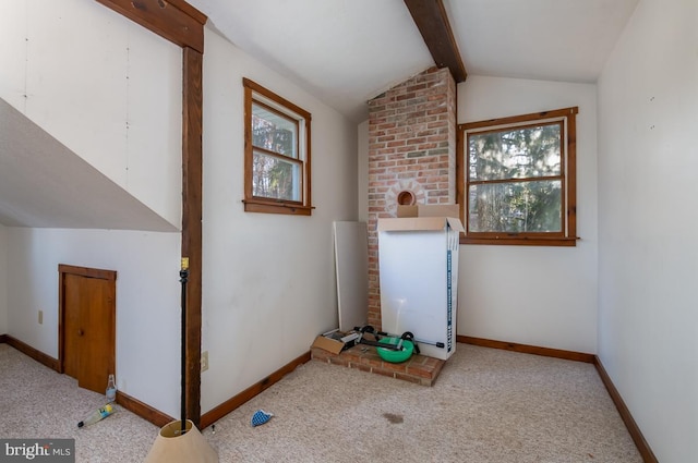 additional living space with lofted ceiling with beams and light carpet