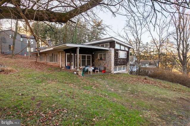 back of house featuring a lawn