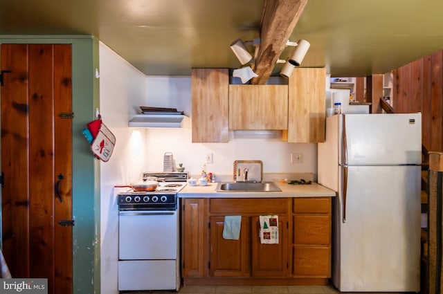 kitchen featuring light tile patterned floors, refrigerator, electric range, and sink