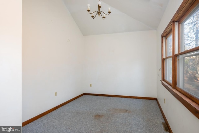 spare room featuring carpet floors, vaulted ceiling, and a notable chandelier