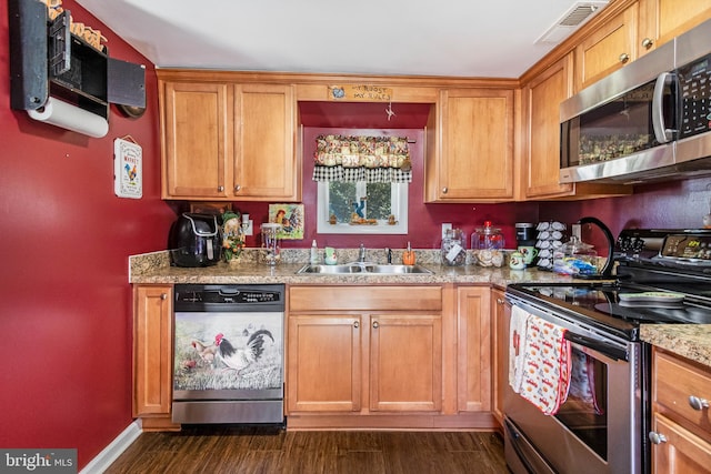 kitchen featuring light stone counters, dark hardwood / wood-style flooring, sink, and appliances with stainless steel finishes