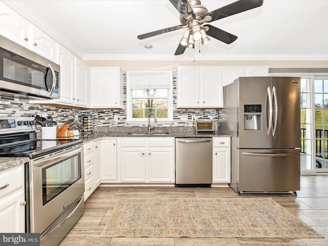 kitchen with appliances with stainless steel finishes, sink, and white cabinets