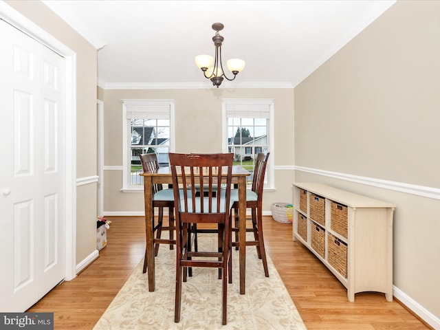 dining area featuring a notable chandelier, crown molding, and light hardwood / wood-style flooring