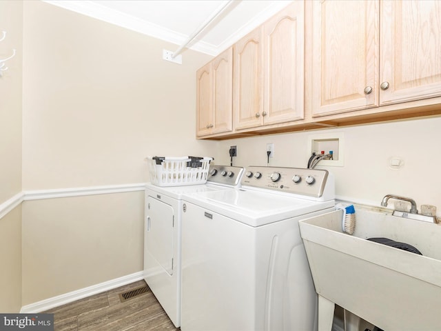 laundry room featuring cabinets, washing machine and dryer, sink, and ornamental molding