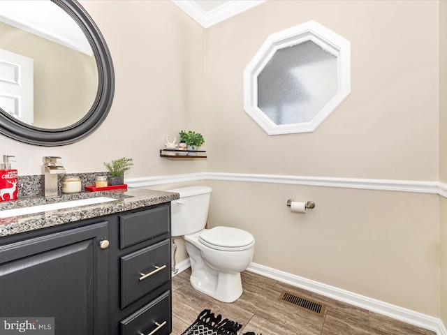 bathroom with vanity, crown molding, and toilet