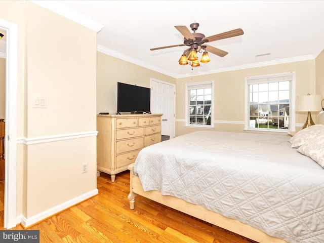 bedroom with ornamental molding, light hardwood / wood-style floors, a closet, and ceiling fan