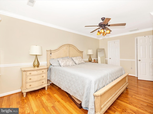 bedroom featuring ornamental molding, light hardwood / wood-style floors, and ceiling fan