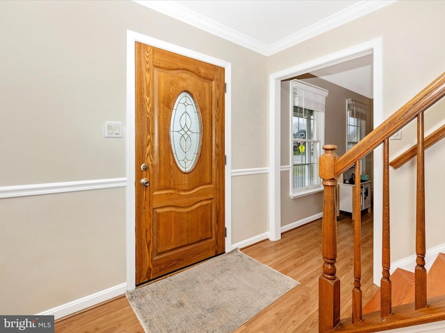 foyer with ornamental molding and light wood-type flooring