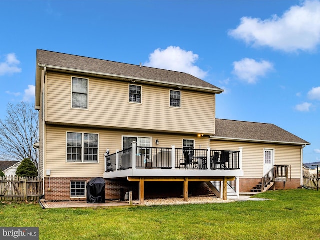 back of house featuring a deck and a lawn