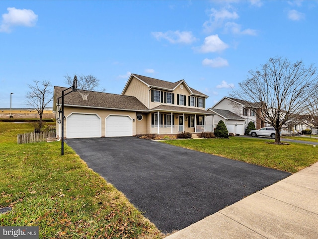 view of property with a porch, a garage, and a front yard