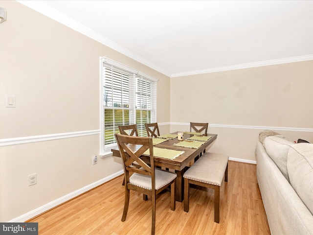 dining room with light hardwood / wood-style flooring and ornamental molding