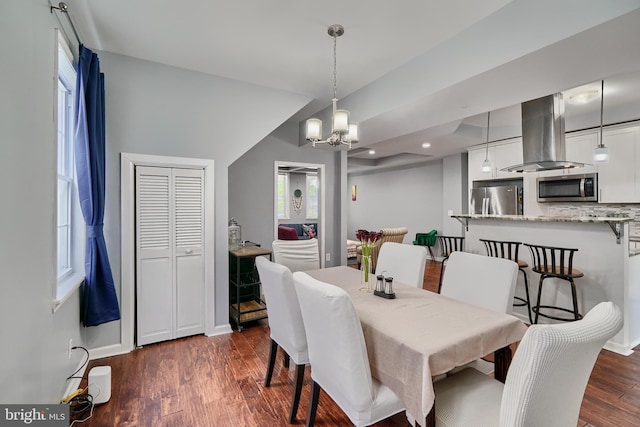 dining space with a chandelier and dark hardwood / wood-style flooring