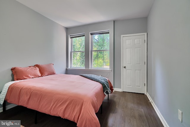 bedroom with dark wood-type flooring