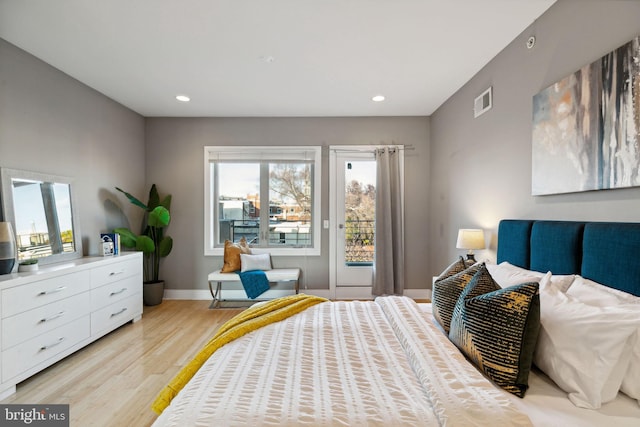 bedroom with multiple windows and light hardwood / wood-style floors