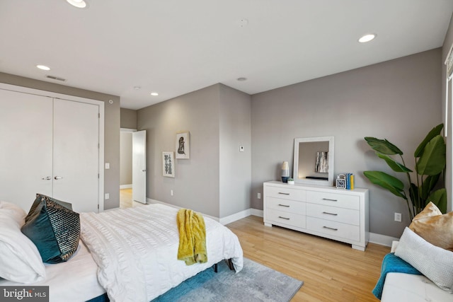 bedroom with a closet and light hardwood / wood-style flooring