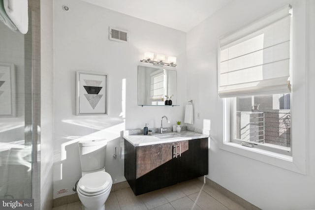 bathroom featuring a wealth of natural light, tile patterned flooring, vanity, and toilet