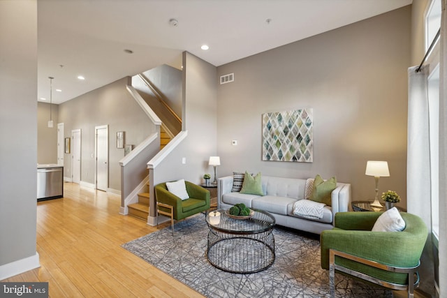 living room featuring hardwood / wood-style floors and a towering ceiling