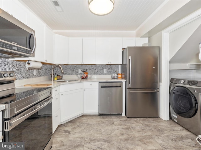 kitchen featuring white cabinetry, sink, tasteful backsplash, washer / dryer, and appliances with stainless steel finishes