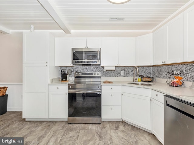 kitchen featuring white cabinets, decorative backsplash, sink, and appliances with stainless steel finishes